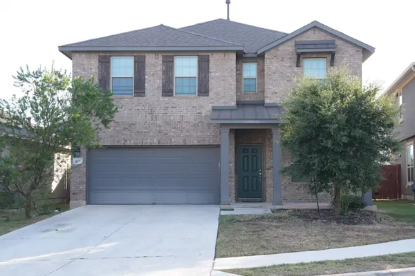a front view of a house with a garden and garage