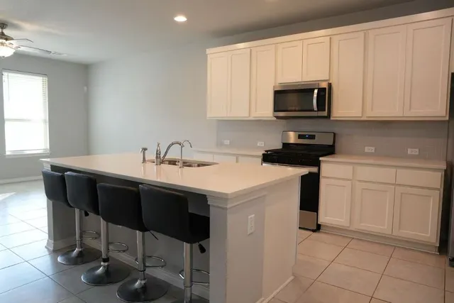 a kitchen that has a sink and a stove top oven