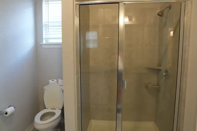 a bathroom with a granite countertop toilet a sink and shower