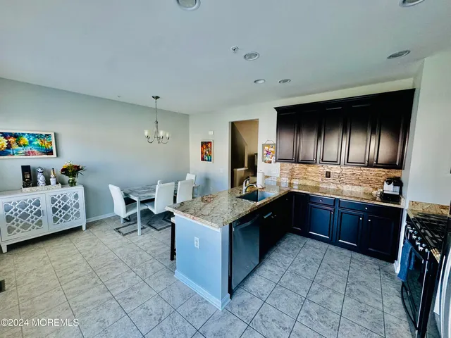 a kitchen with stainless steel appliances granite countertop a stove a refrigerator and a sink