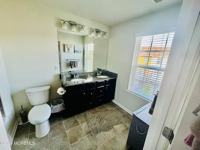 a bathroom with a sink vanity mirror and toilet