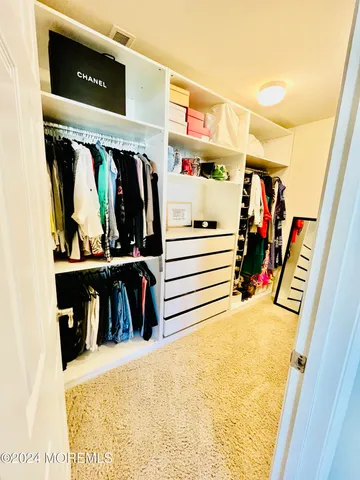 a view of walk in closet with clothes and shoes