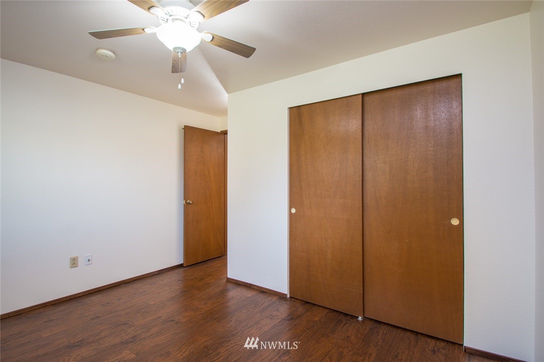 15467 Beaver Marsh Road Mount Vernon, WA 98273 - Photo 13 of 23 an empty room with wooden floor closet fan and windows