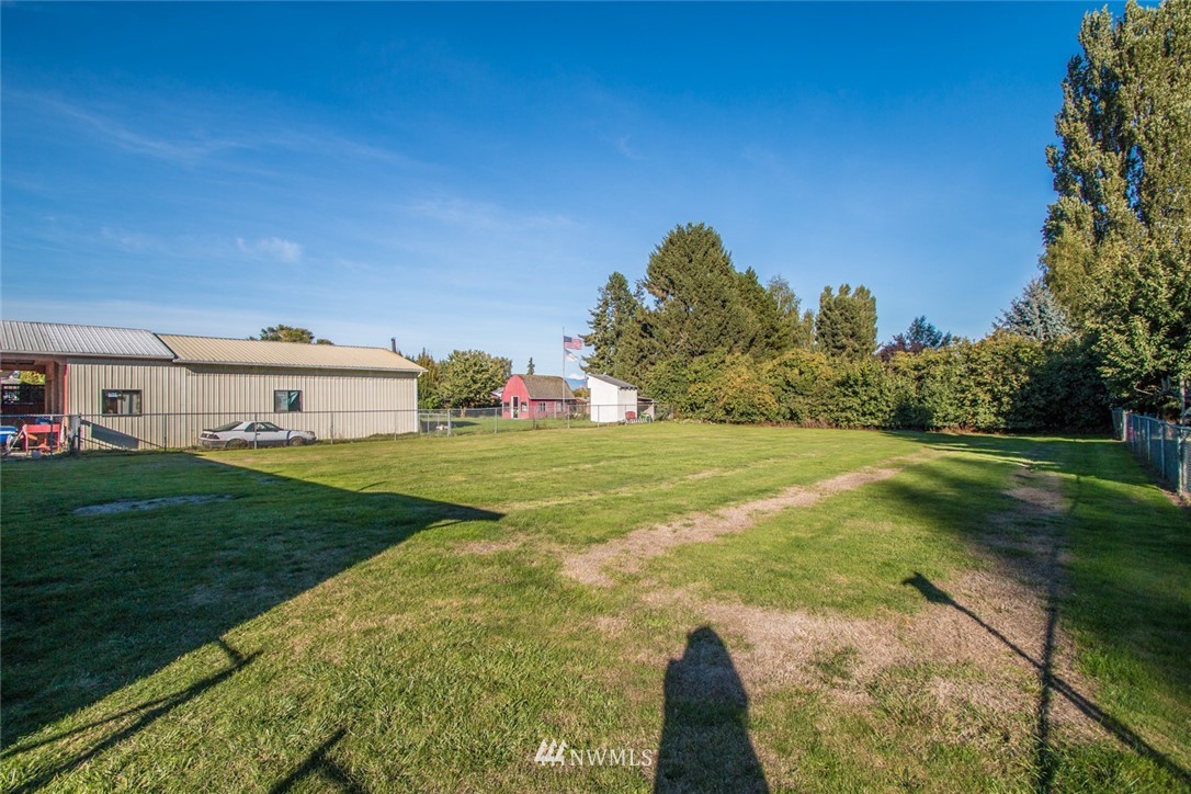 15467 Beaver Marsh Road Mount Vernon, WA 98273 - Photo 21 of 23 a view of a white house in front of a big yard with plants and large trees
