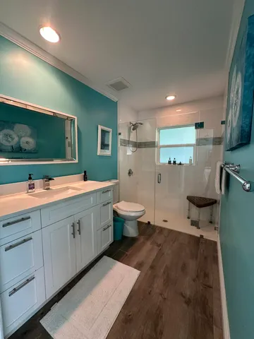 a spacious bathroom with a double vanity sink a mirror and a toilet