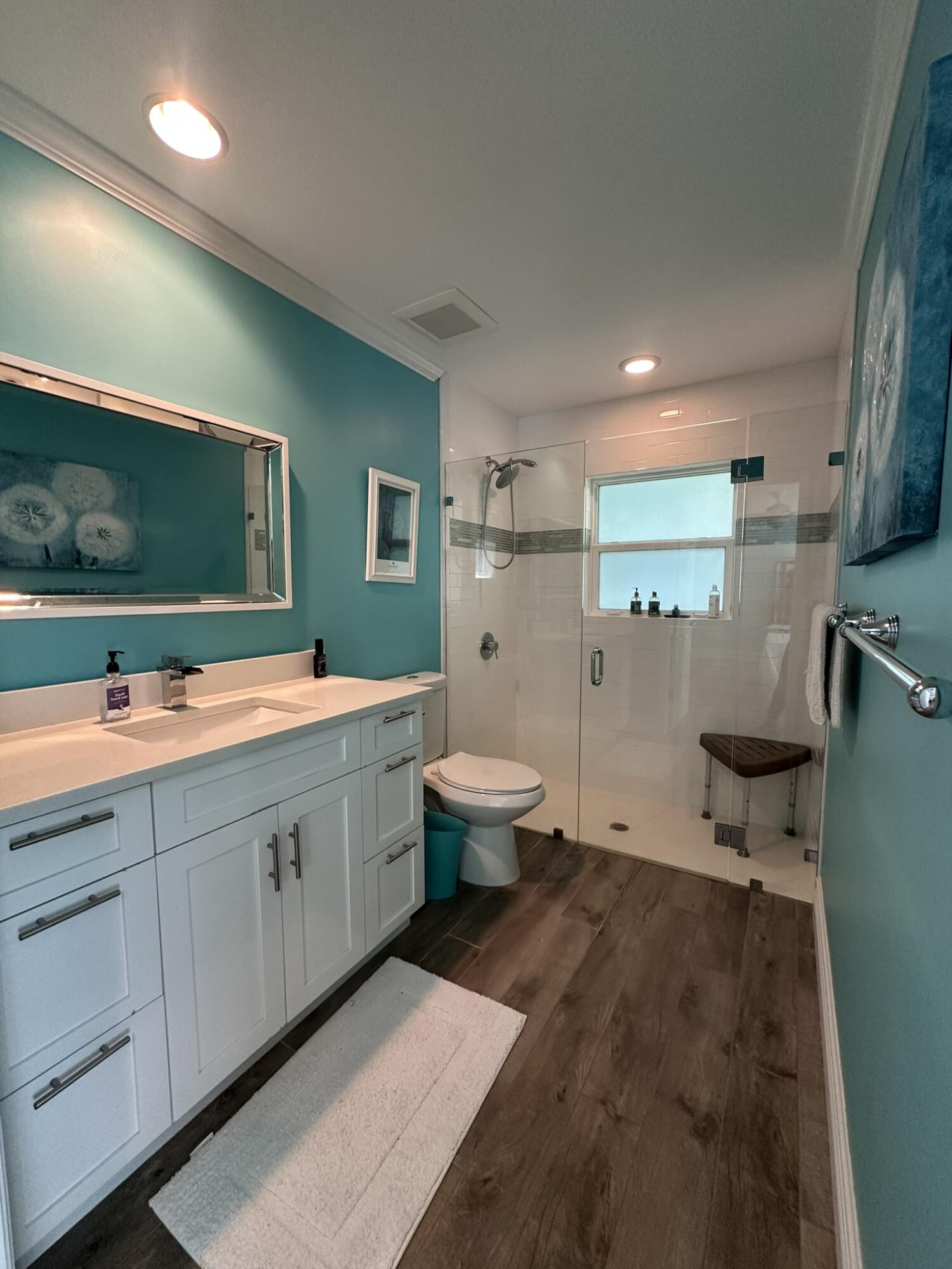 2415 Laurel Lane Palm Beach Gardens, FL 33410 - Photo 11 of 18 a spacious bathroom with a double vanity sink a mirror and a toilet