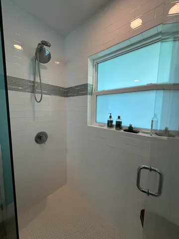 a bathroom with a shower and a mirror