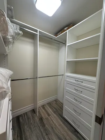 a view of walk in closet with empty racks