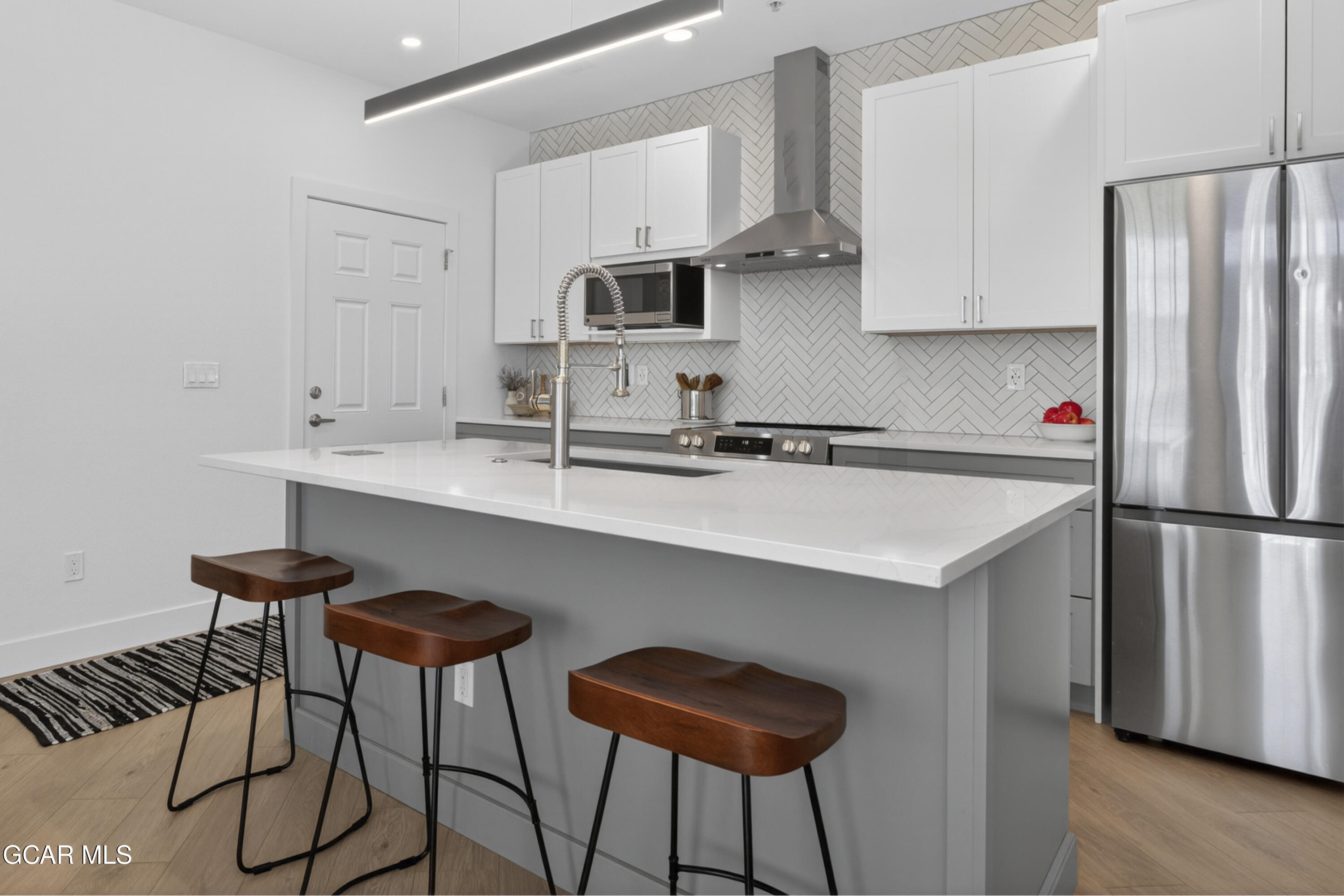 160 Village Road, Unit F207 Granby, CO 80446 - Photo 6 of 28 a kitchen with stainless steel appliances a sink a refrigerator and white cabinets