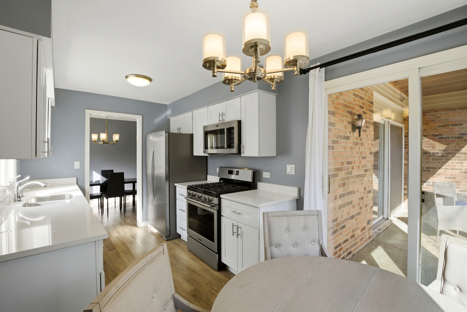 622 Zaininger Avenue, Unit A Naperville, IL 60563 - Photo 12 of 30 a kitchen with a stove a sink a chandelier and living room view