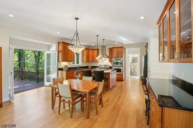 a view of a dining room and livingroom with furniture wooden floor a chandelier