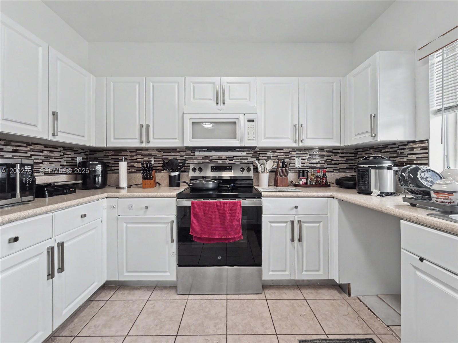 14264 Southwest 289th Terrace Homestead, FL 33033 - Photo 11 of 23 a kitchen with stainless steel appliances granite countertop a stove a sink and white cabinets