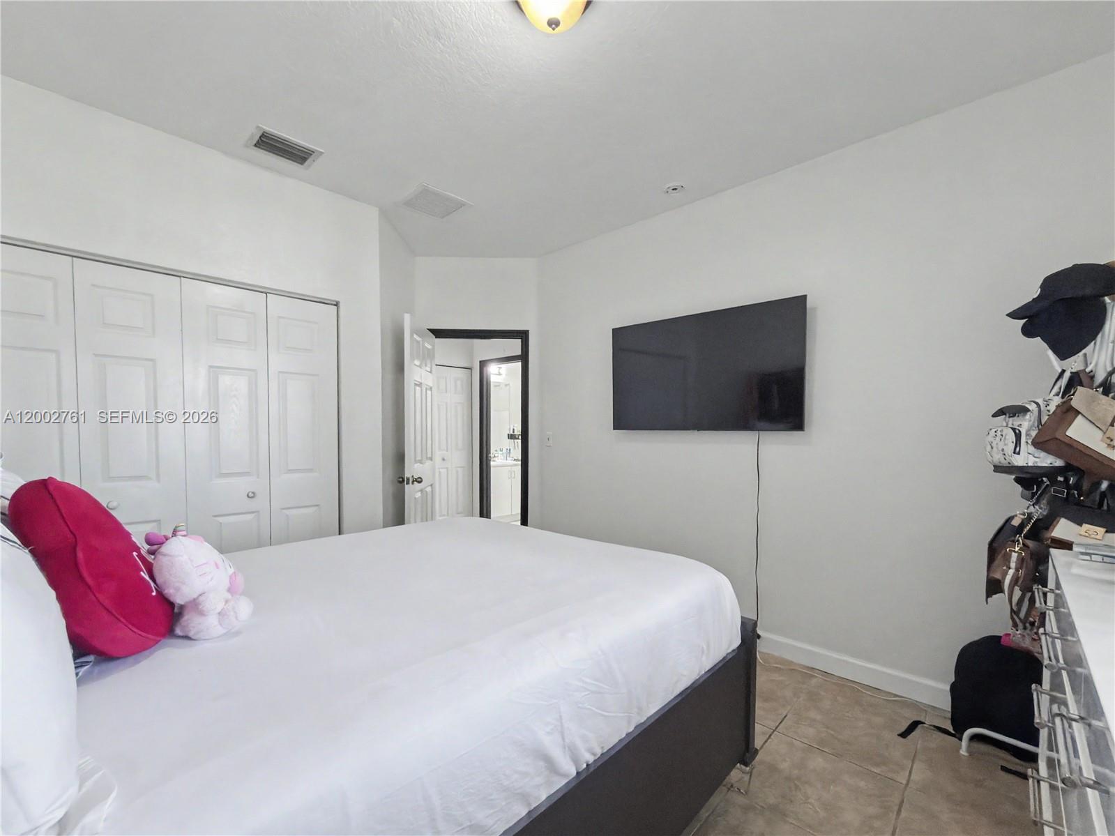 14264 Southwest 289th Terrace Homestead, FL 33033 - Photo 12 of 23 a bedroom with a bed and a flat tv screen on dresser