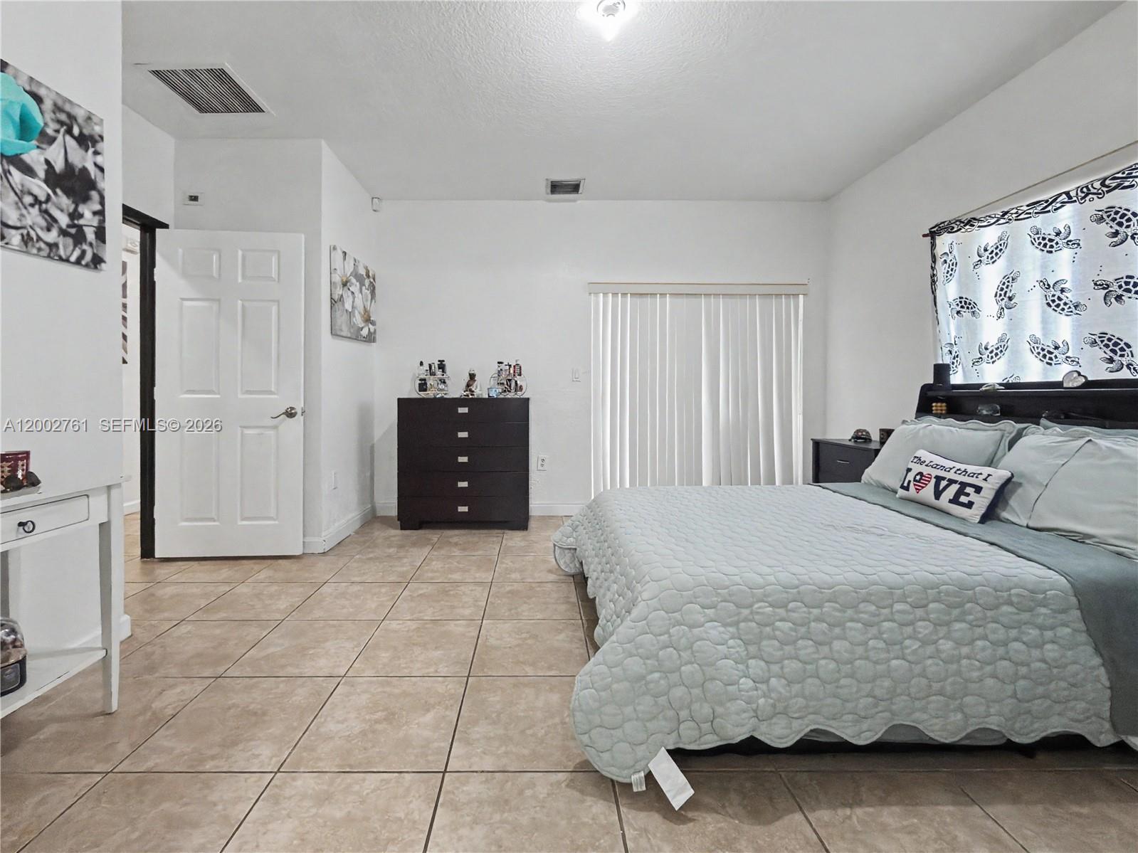 14264 Southwest 289th Terrace Homestead, FL 33033 - Photo 15 of 23 a bedroom with a bed and painting on the wall