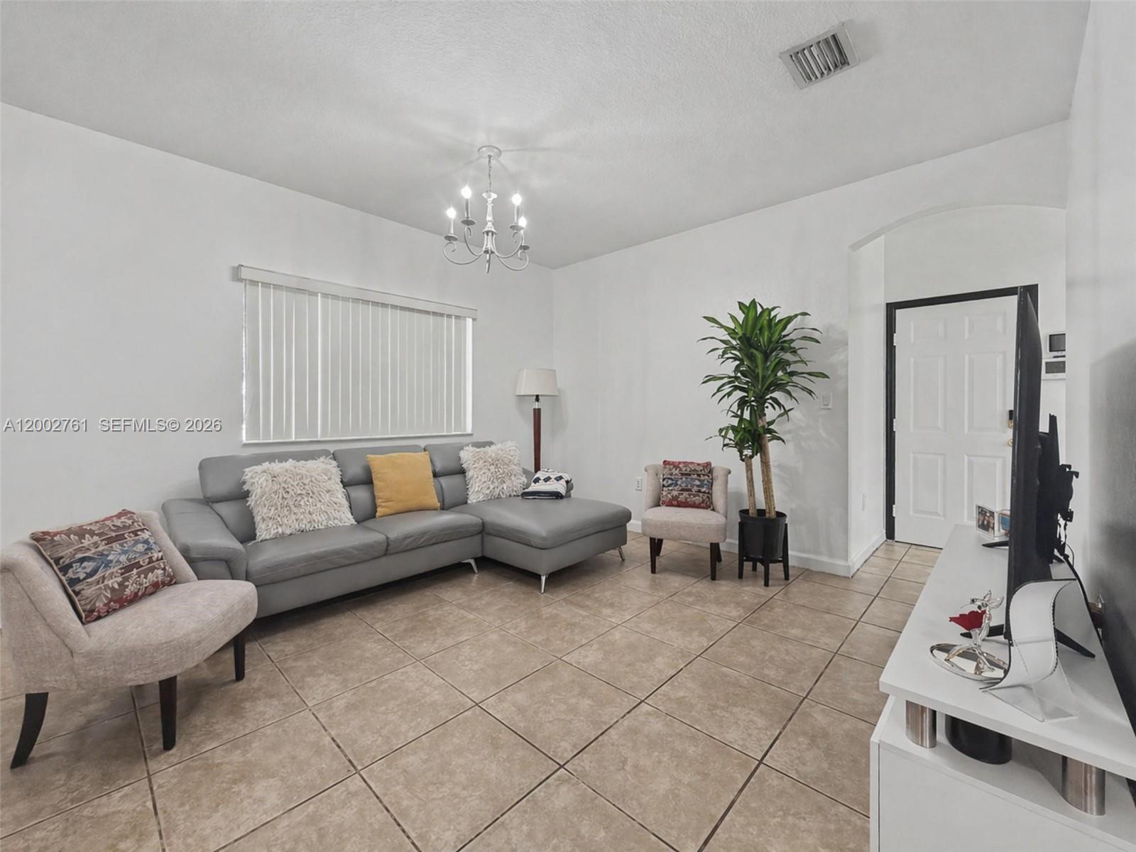 14264 Southwest 289th Terrace Homestead, FL 33033 - Photo 5 of 23 a living room with furniture and a chandelier