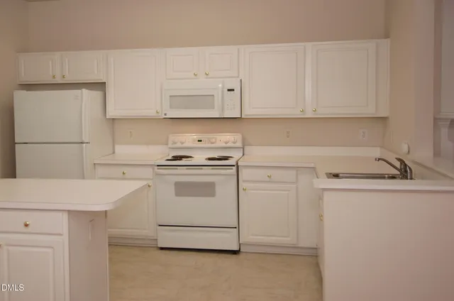 a kitchen with white cabinets and white appliances
