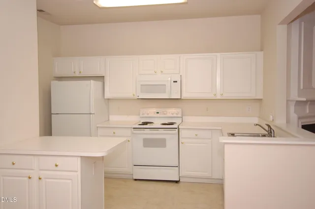 a kitchen with cabinets appliances a sink and a counter space