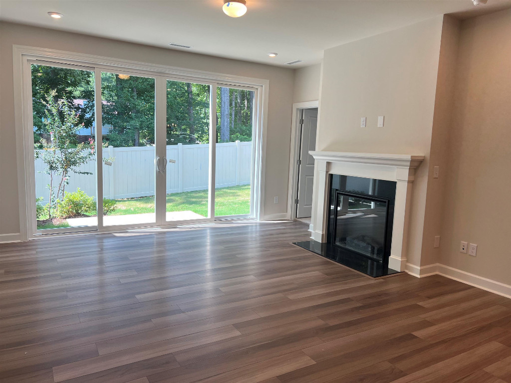 7809 Sofiana Avenue Raleigh, NC 27617 - Photo 11 of 20 a view of empty room with wooden floor and fireplace