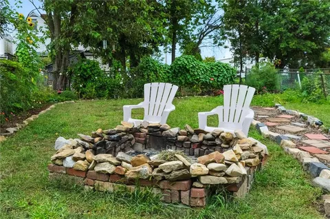 a view of a chair and fire pit in the garden