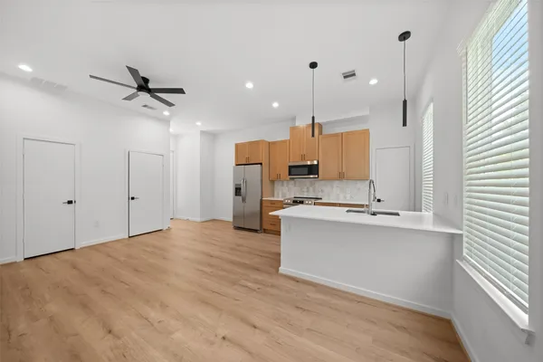 a view of kitchen with sink and refrigerator
