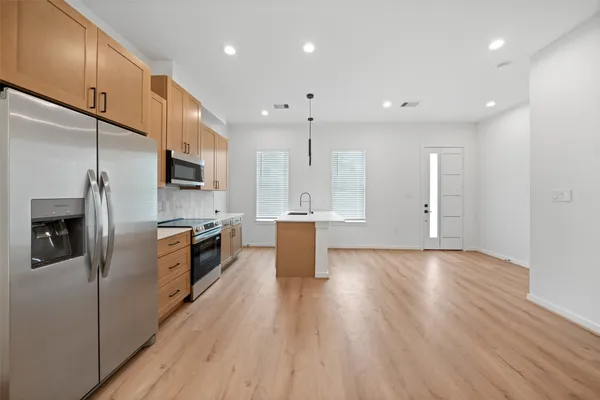 a kitchen with stainless steel appliances a refrigerator sink and microwave