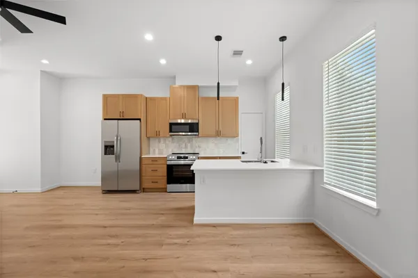 a kitchen with stainless steel appliances a refrigerator sink and microwave