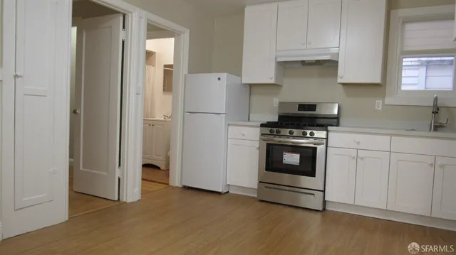 a kitchen with white cabinets and white appliances