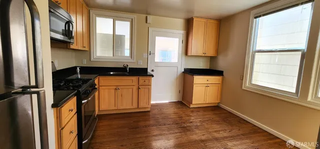 a kitchen with granite countertop a stove a sink and a granite counter tops