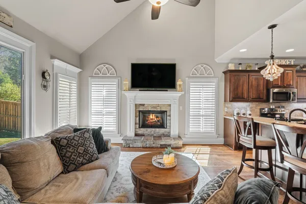 a living room with furniture a flat screen tv and a fireplace