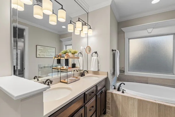 a bathroom with a sink a large mirror and a bathtub