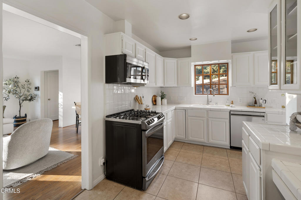 3624 Canyon Crest Road Altadena, CA 91001 - Photo 20 of 57 a kitchen with a sink stove and wooden cabinets