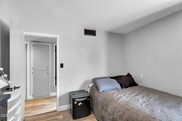 a bedroom with a bed and wooden floor