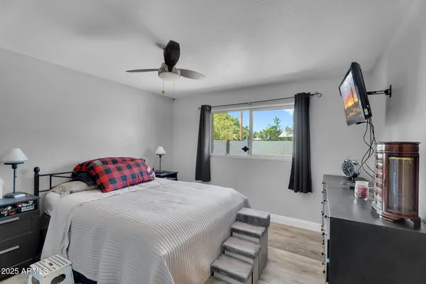 a bedroom with a bed and a flat tv screen on the dresser