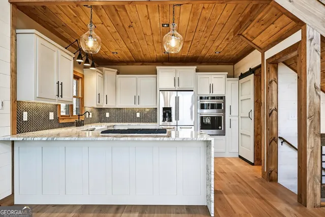 a kitchen with white cabinets and appliances