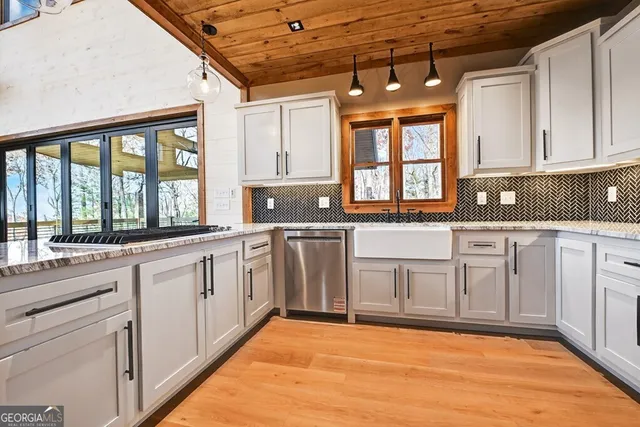 a kitchen with stainless steel appliances granite countertop a sink and cabinets