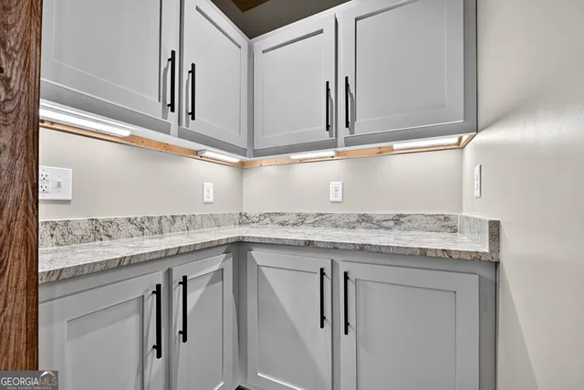 an empty room with wooden floor closet and windows