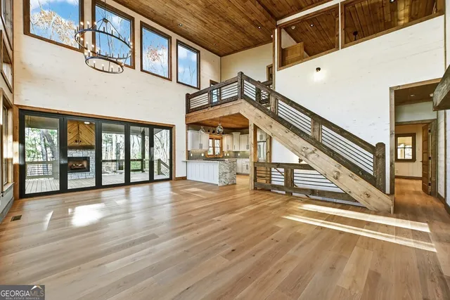 a view of an empty room with wooden floor and a fireplace