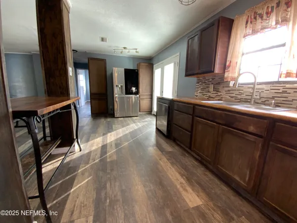a large kitchen with stainless steel appliances kitchen island granite countertop a sink stove and cabinets
