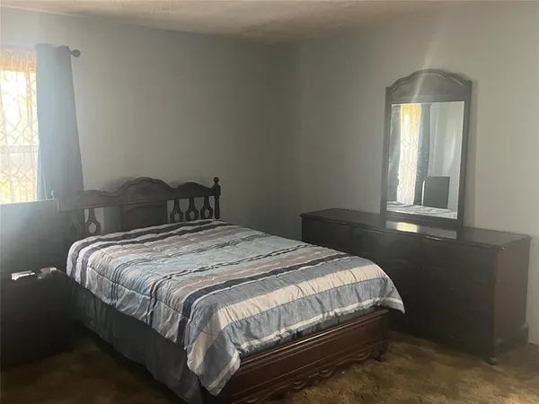a bedroom with a bed and a window