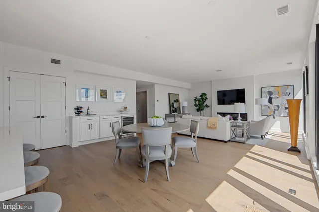 a living room with furniture a large window and a chandelier