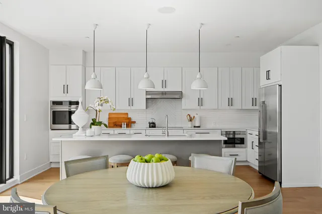 a kitchen with white cabinets and sink