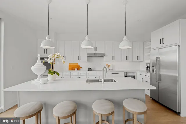 a kitchen with stainless steel appliances a sink a stove and a wooden floor