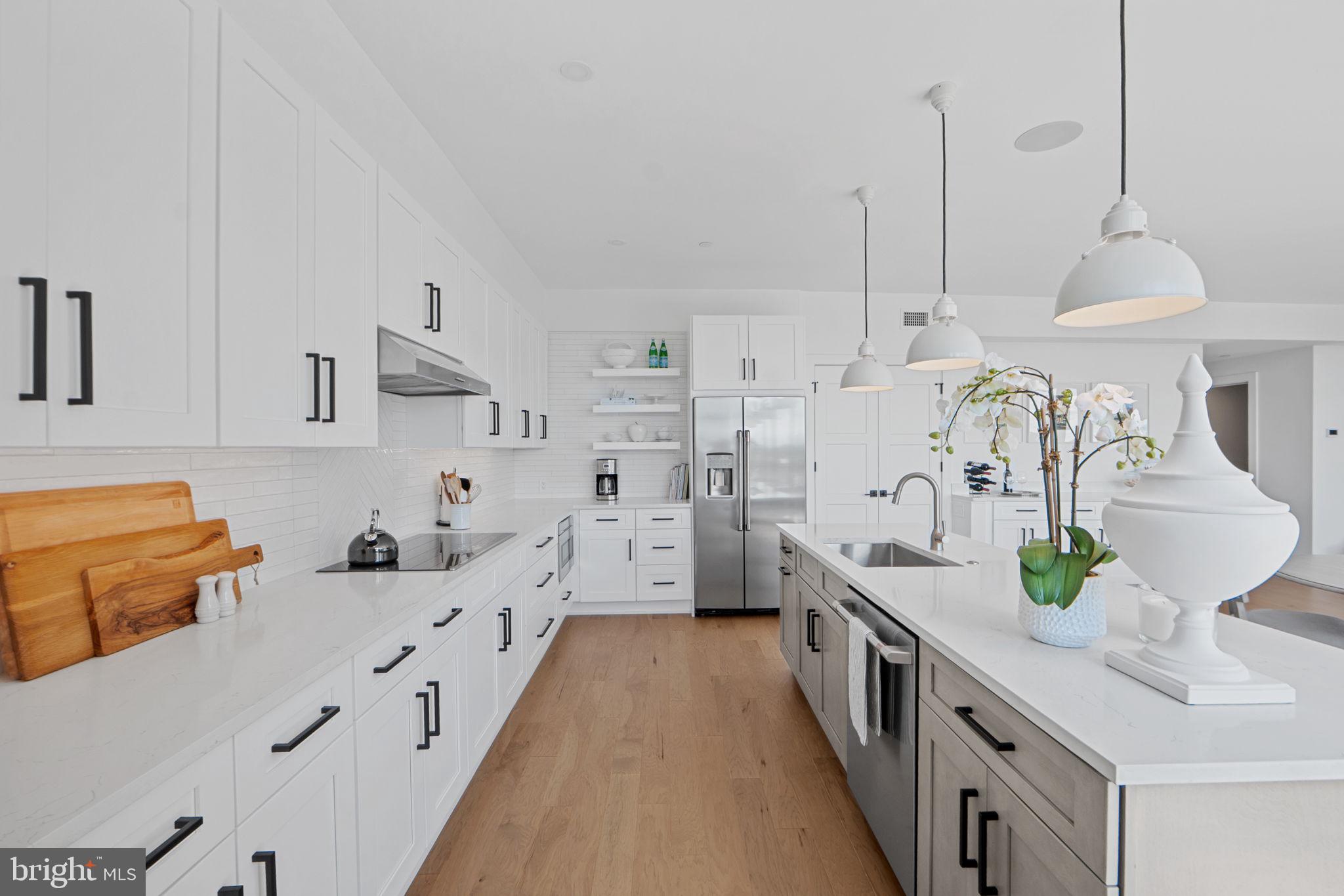 210 East 2nd Street, Unit 402 Frederick, MD 21701 - Photo 26 of 71 a kitchen with stainless steel appliances a sink stove and wooden floor