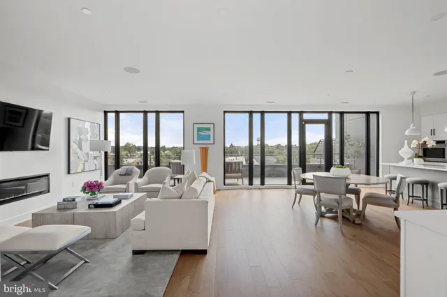 a living room with furniture a flat screen tv and a large window