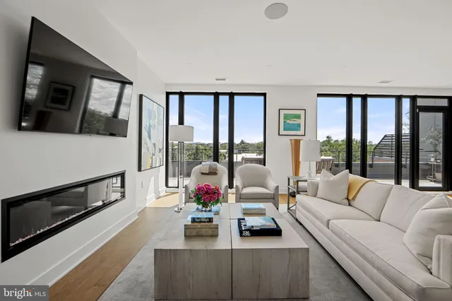 a living room with furniture a large window and a flat screen tv