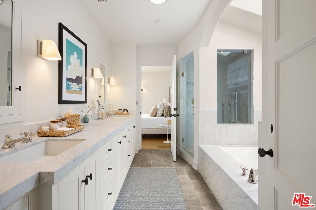 765 Ranch Lane Pacific Palisades, CA 90272 - Photo 14 of 23 a spacious bathroom with a double vanity sink a mirror and a bathtub