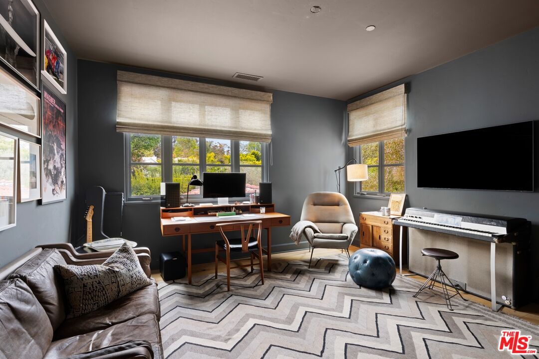 765 Ranch Lane Pacific Palisades, CA 90272 - Photo 18 of 23 a work room with furniture a flat screen tv and a window