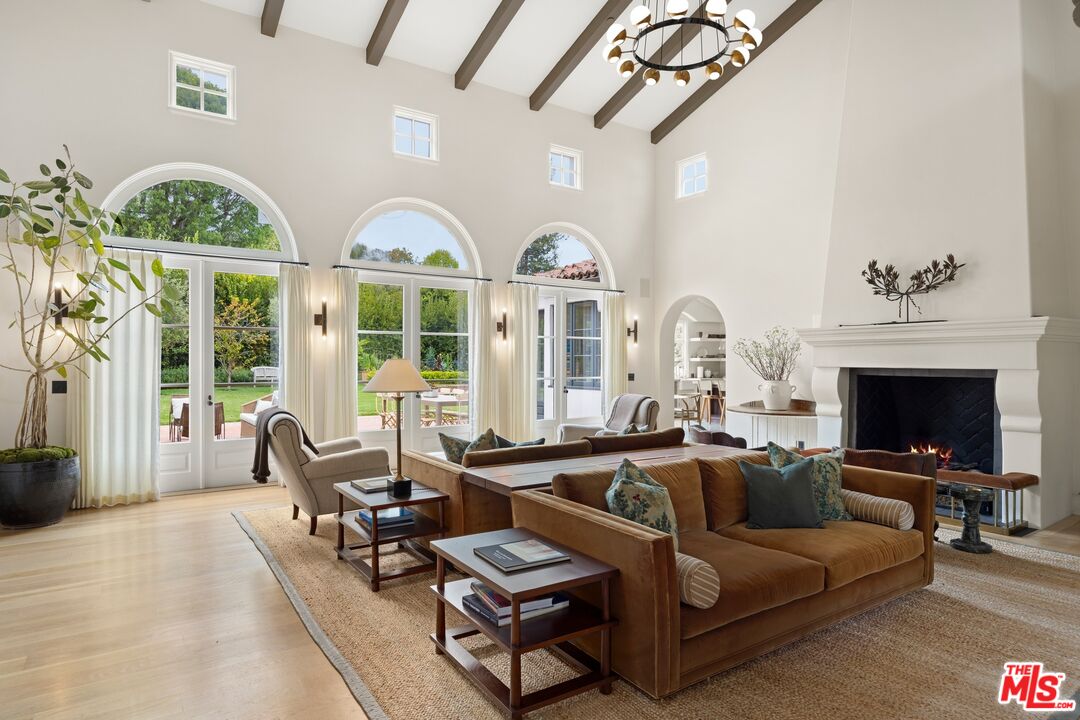 765 Ranch Lane Pacific Palisades, CA 90272 - Photo 5 of 23 a living room with furniture a fireplace and a chandelier