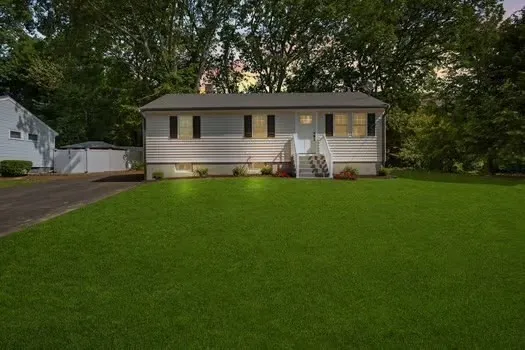 a front view of a house with a garden and yard