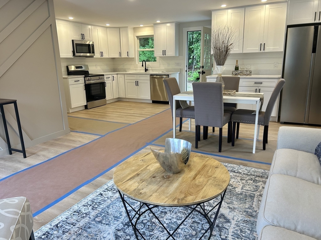 7 Edward Street Canton, MA 02021 - Photo 7 of 22 a kitchen with stainless steel appliances kitchen island granite countertop a sink a stove a dining table and chairs
